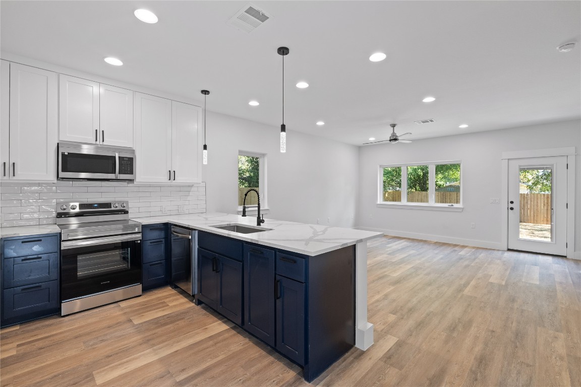 a kitchen with a sink window and stainless steel appliances