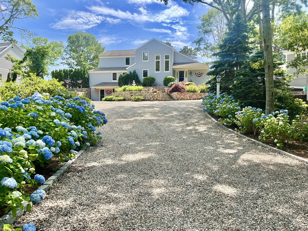 a view of a house with a yard and potted plants