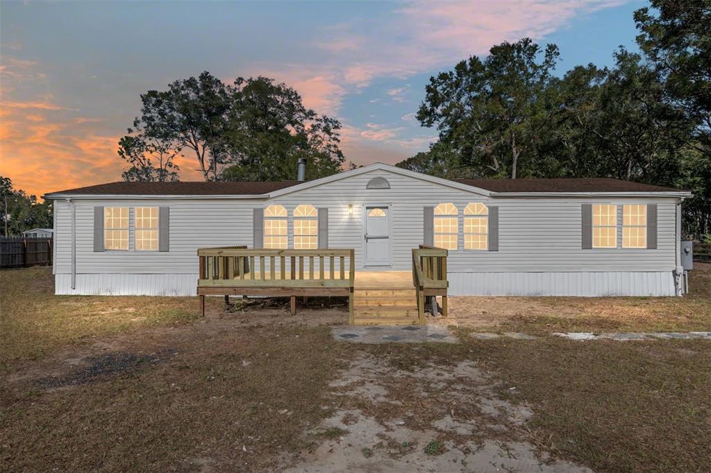 a view of a house with backyard and a tree