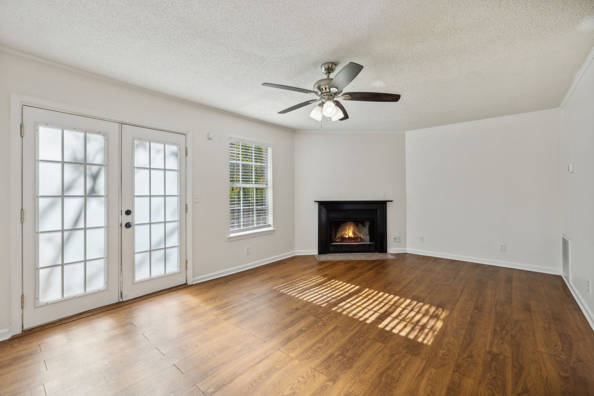 a view of an empty room with a fireplace and a window