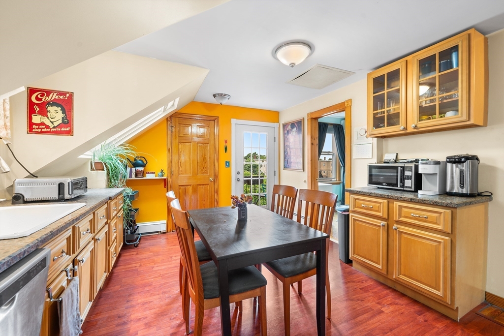 a view of a kitchen filled with furniture and wooden floor