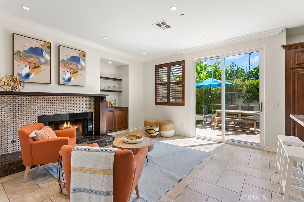 a living room with furniture a fireplace and a large window