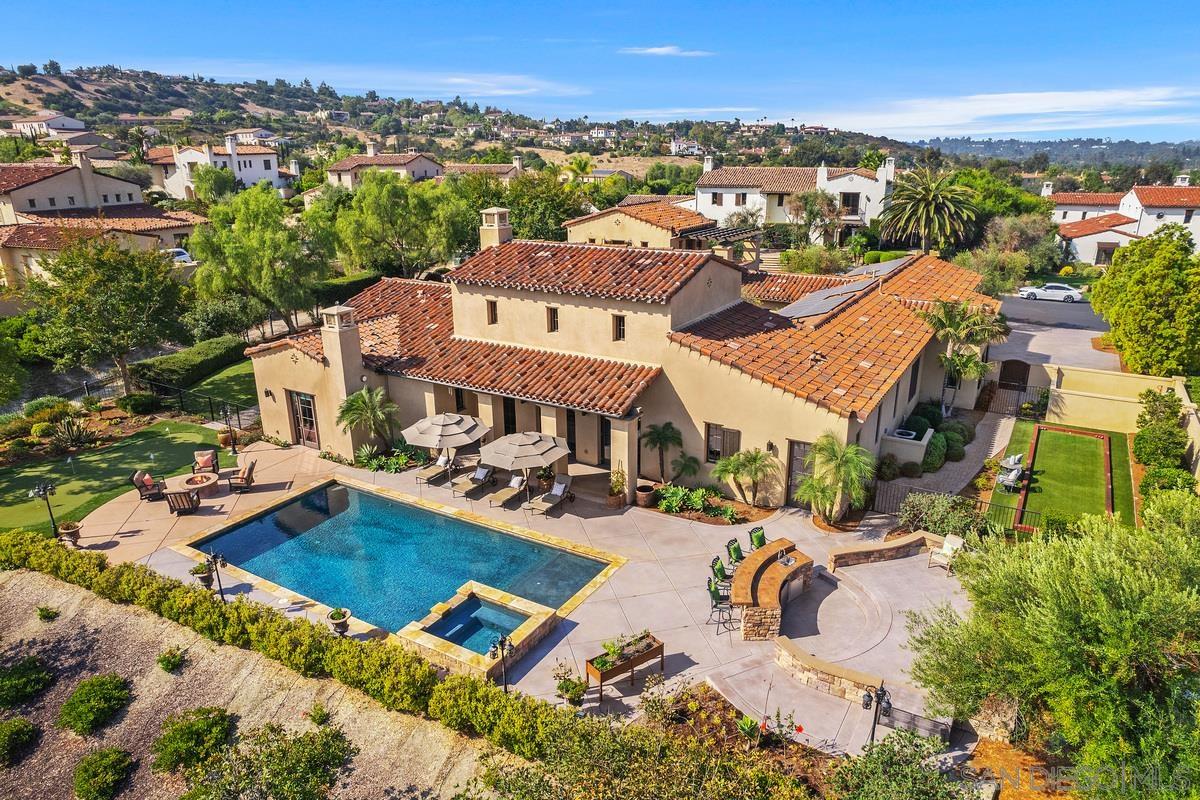 an aerial view of a house with a swimming pool and mountains