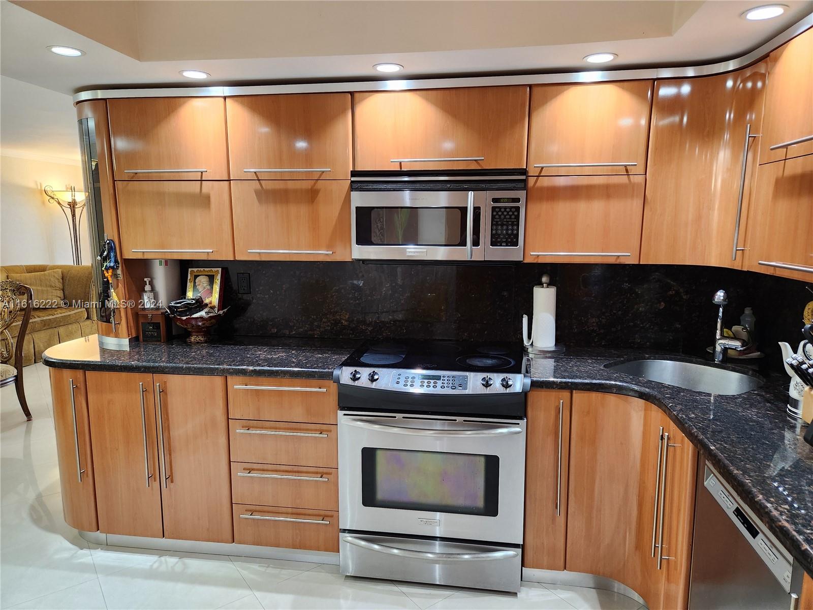 a kitchen with stainless steel appliances granite countertop a stove and a microwave