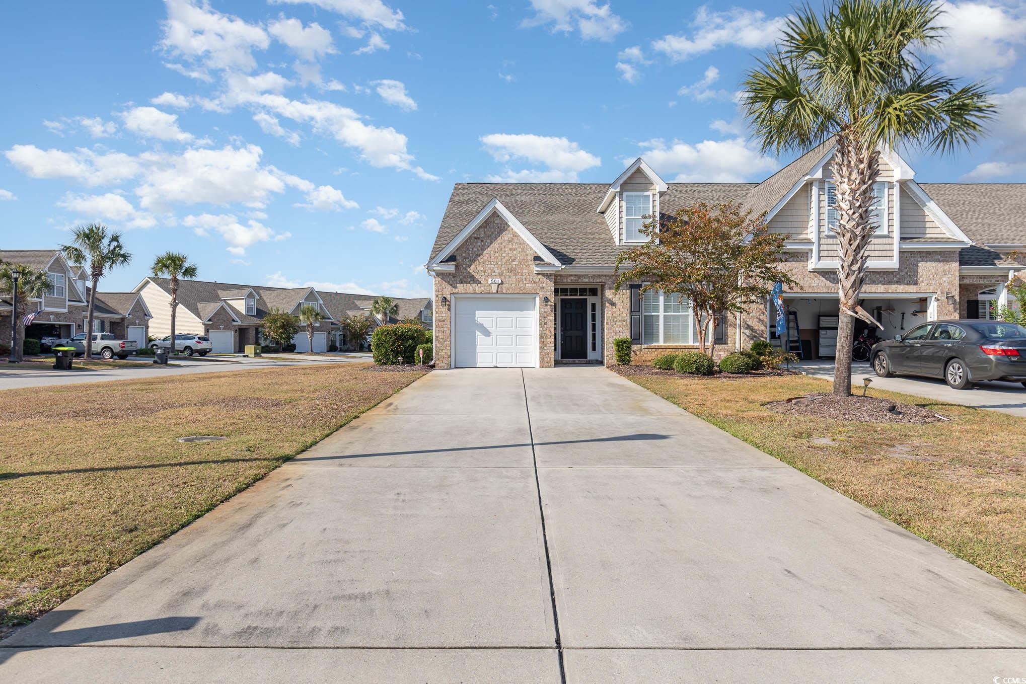 View of front of house with a front lawn and a gar