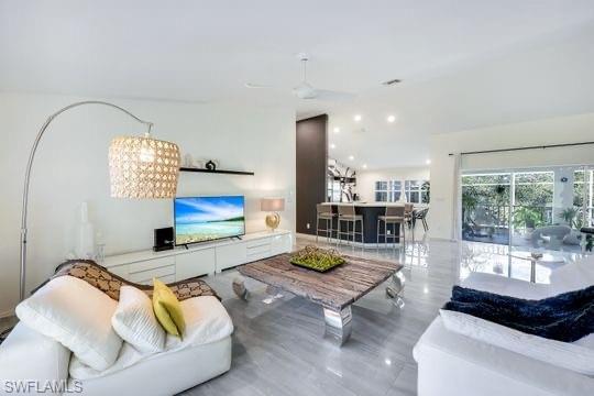 Living room with ceiling fan with notable chandelier