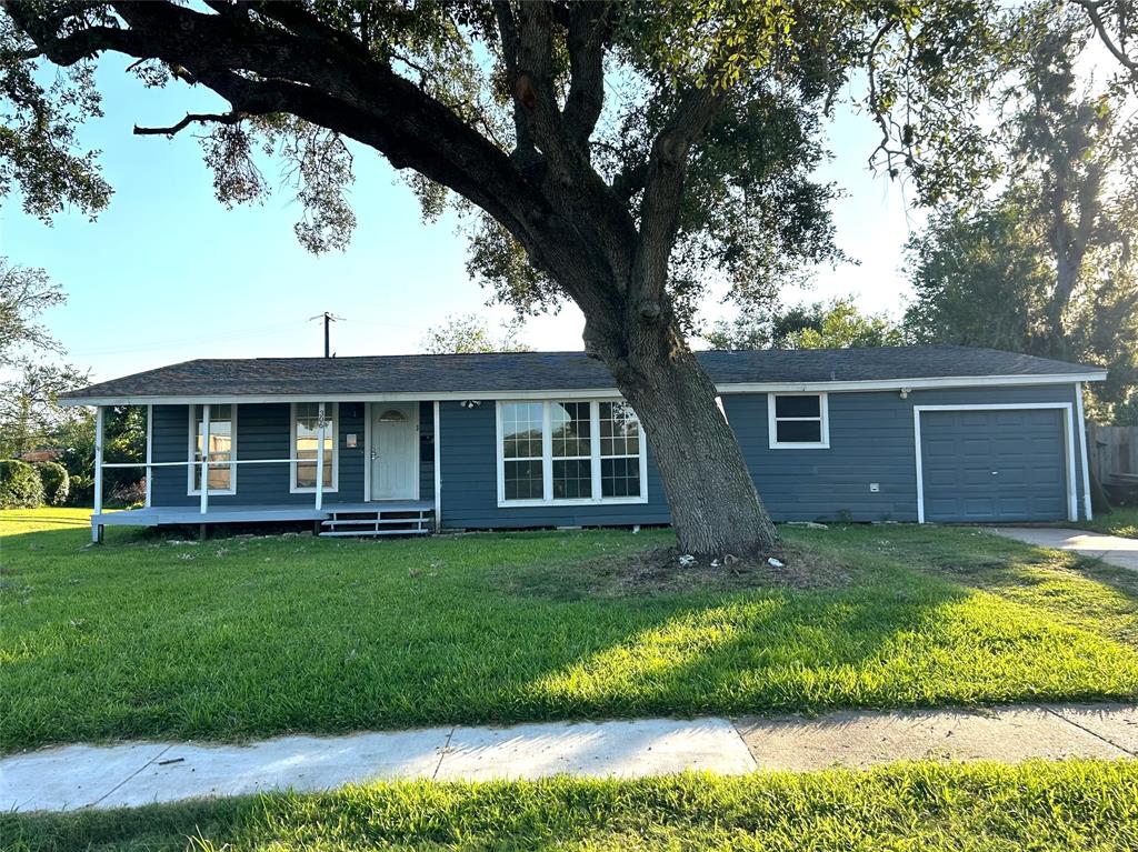 a view of a yard in front of a house with large windows