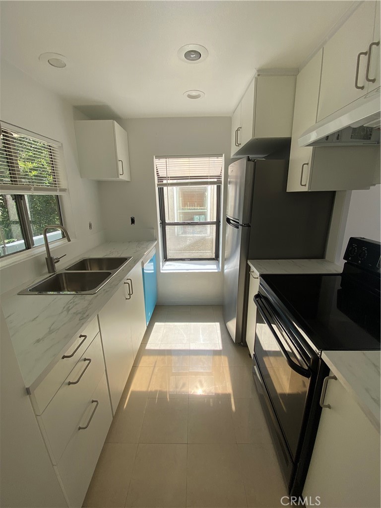 a kitchen with a sink a refrigerator and window