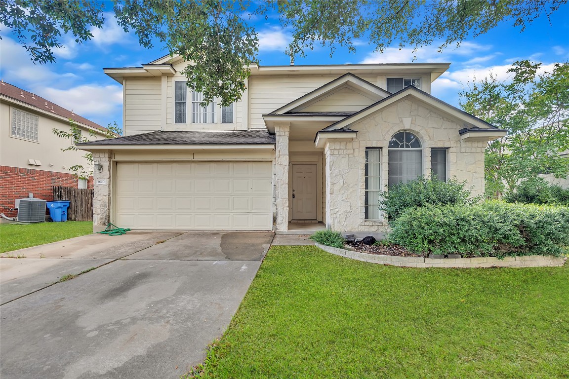 a front view of a house with a yard and garage