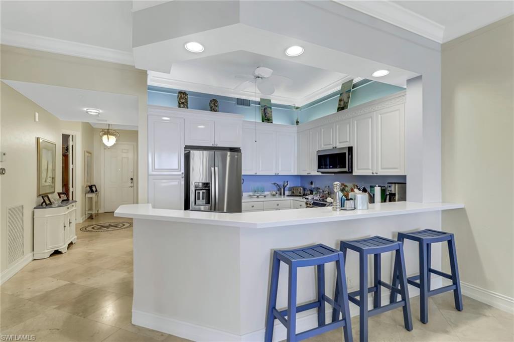 a kitchen with stainless steel appliances kitchen island granite countertop a dining table and chairs