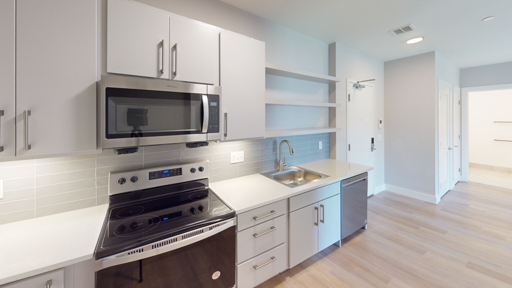 a kitchen with appliances a sink and cabinets