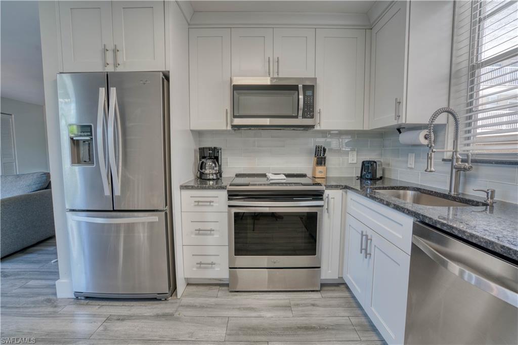 a kitchen with stainless steel appliances granite countertop a refrigerator stove and microwave