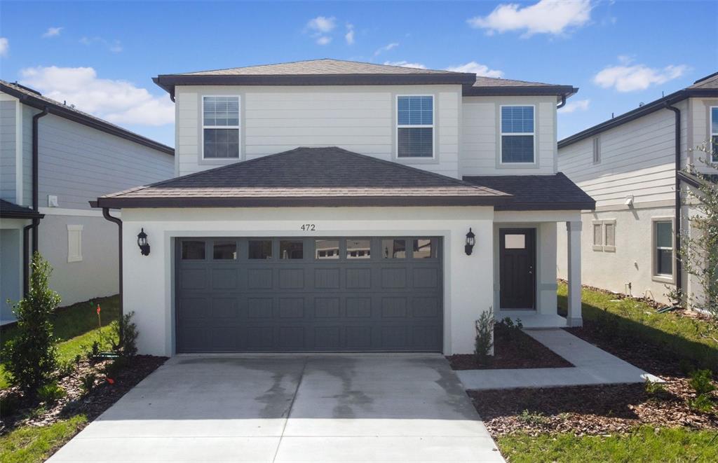 a front view of a house with a yard and garage