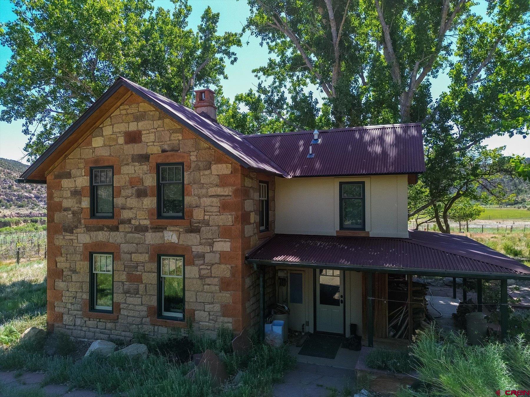 a front view of a house with a yard and trees