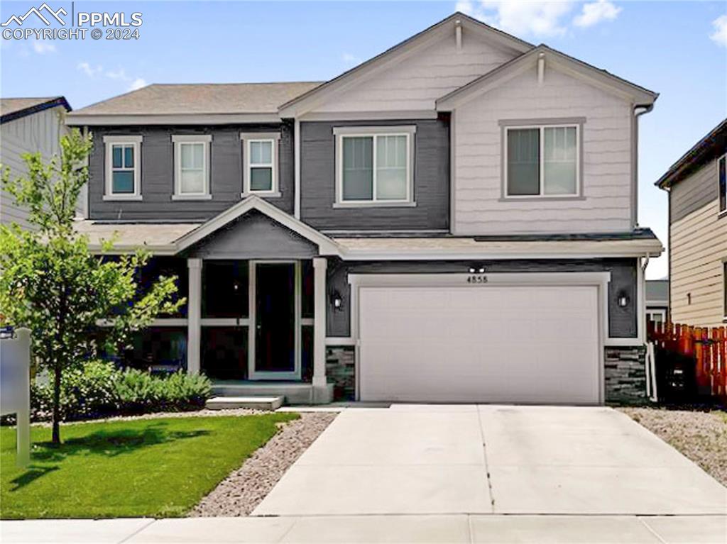 a front view of a house with a yard and garage