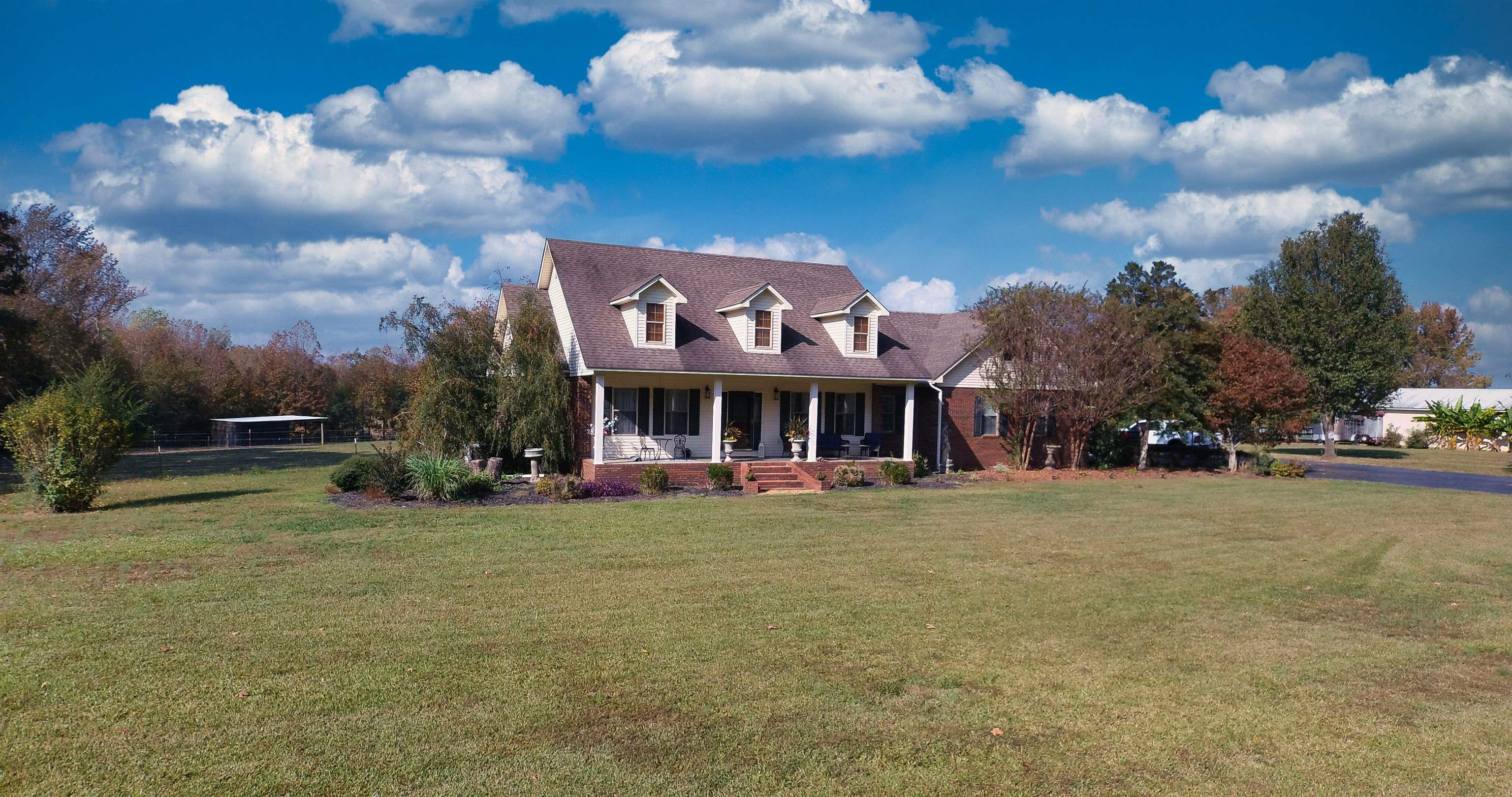 a view of a big house with a big yard and large trees