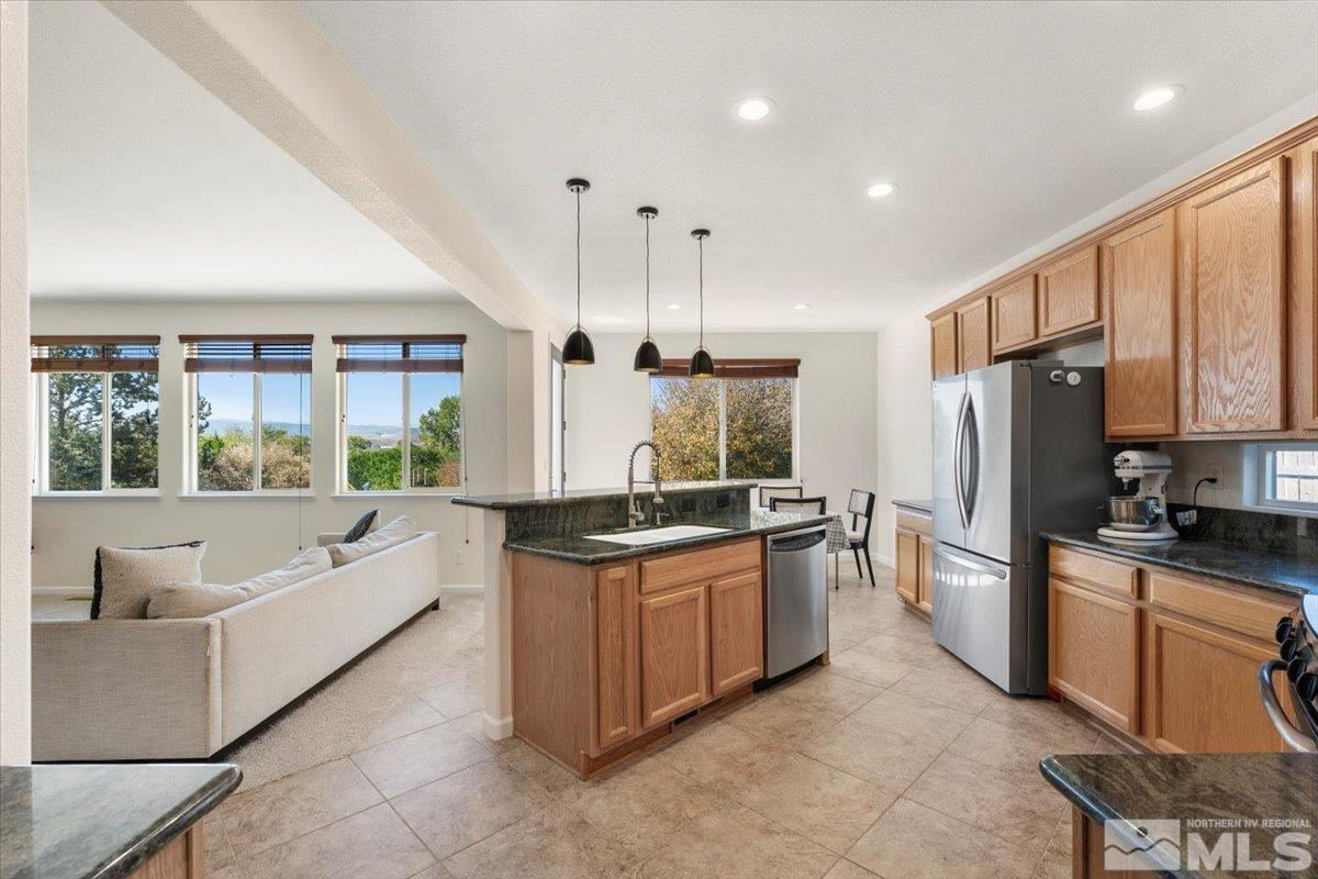 a large kitchen with stainless steel appliances granite countertop a stove and a sink