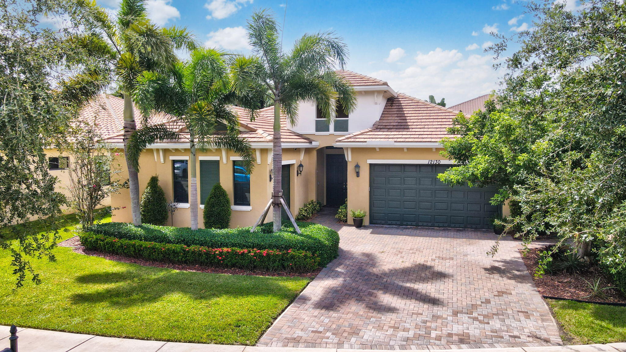 a front view of a house with a yard and trees