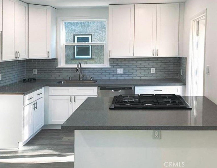 a kitchen with stainless steel appliances granite countertop a sink and a stove