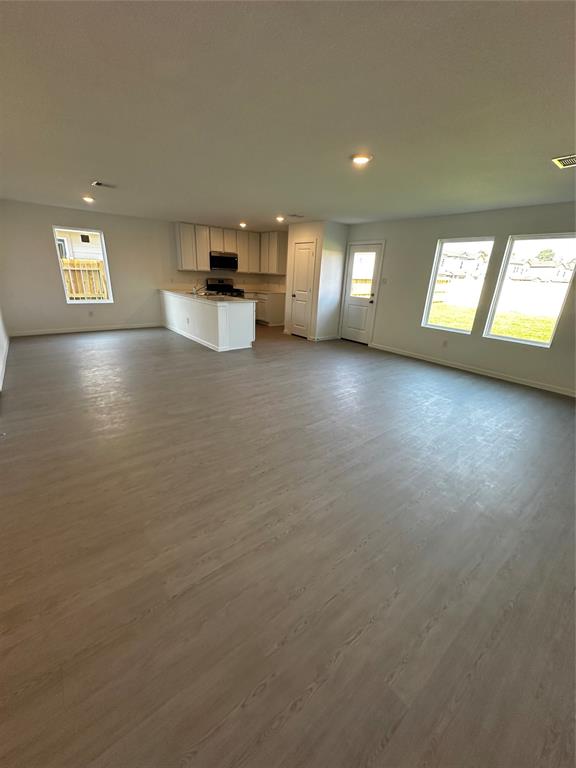 an empty room with windows and ceiling fan