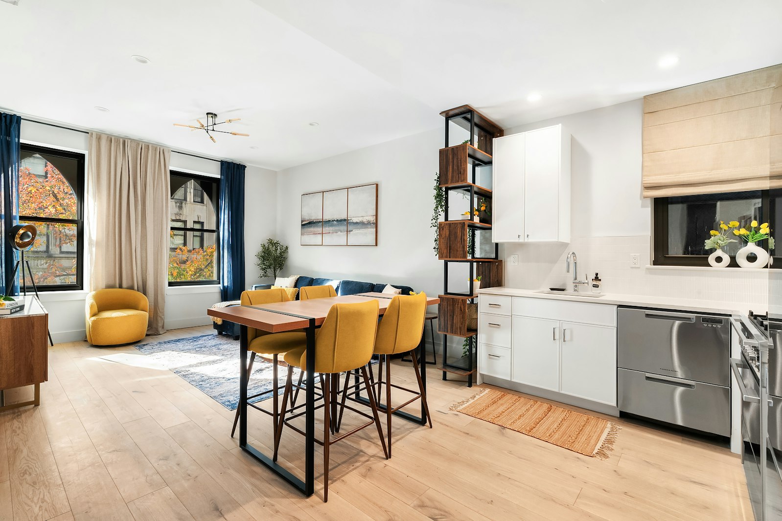 a spacious bathroom with a table chairs sink and wooden floor