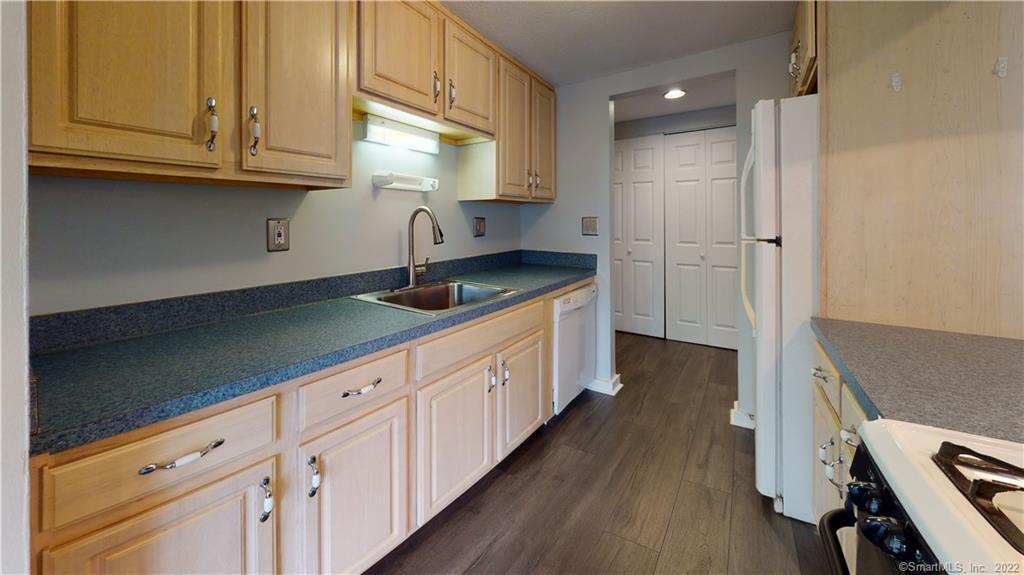 a kitchen with granite countertop a sink a stove and cabinets