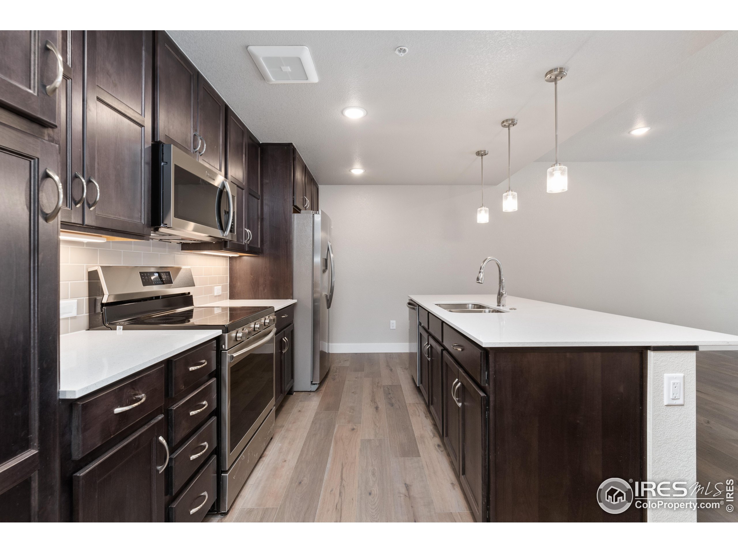 a kitchen with stainless steel appliances granite countertop a sink a stove and a refrigerator