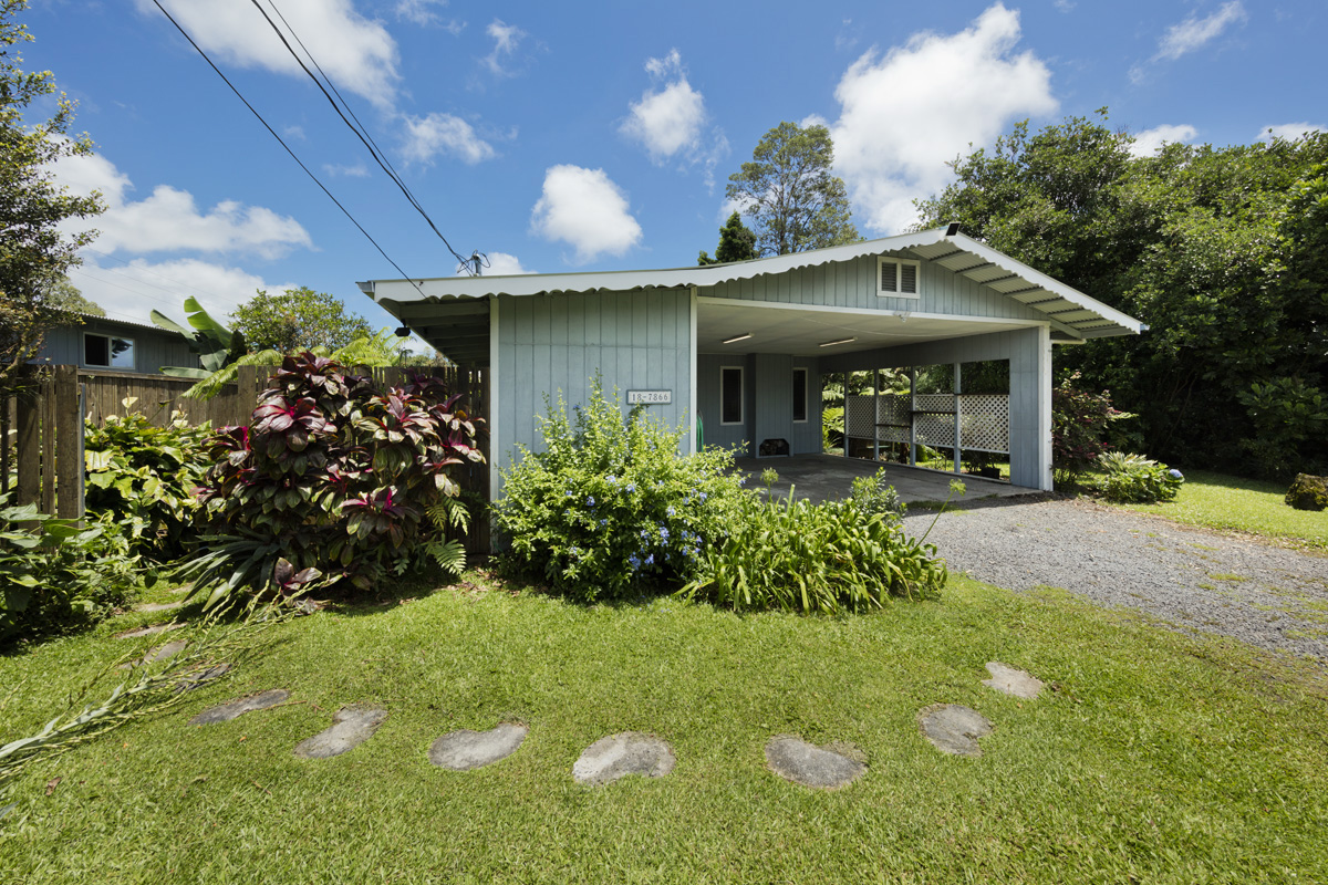 a front view of a house with a yard and potted plants