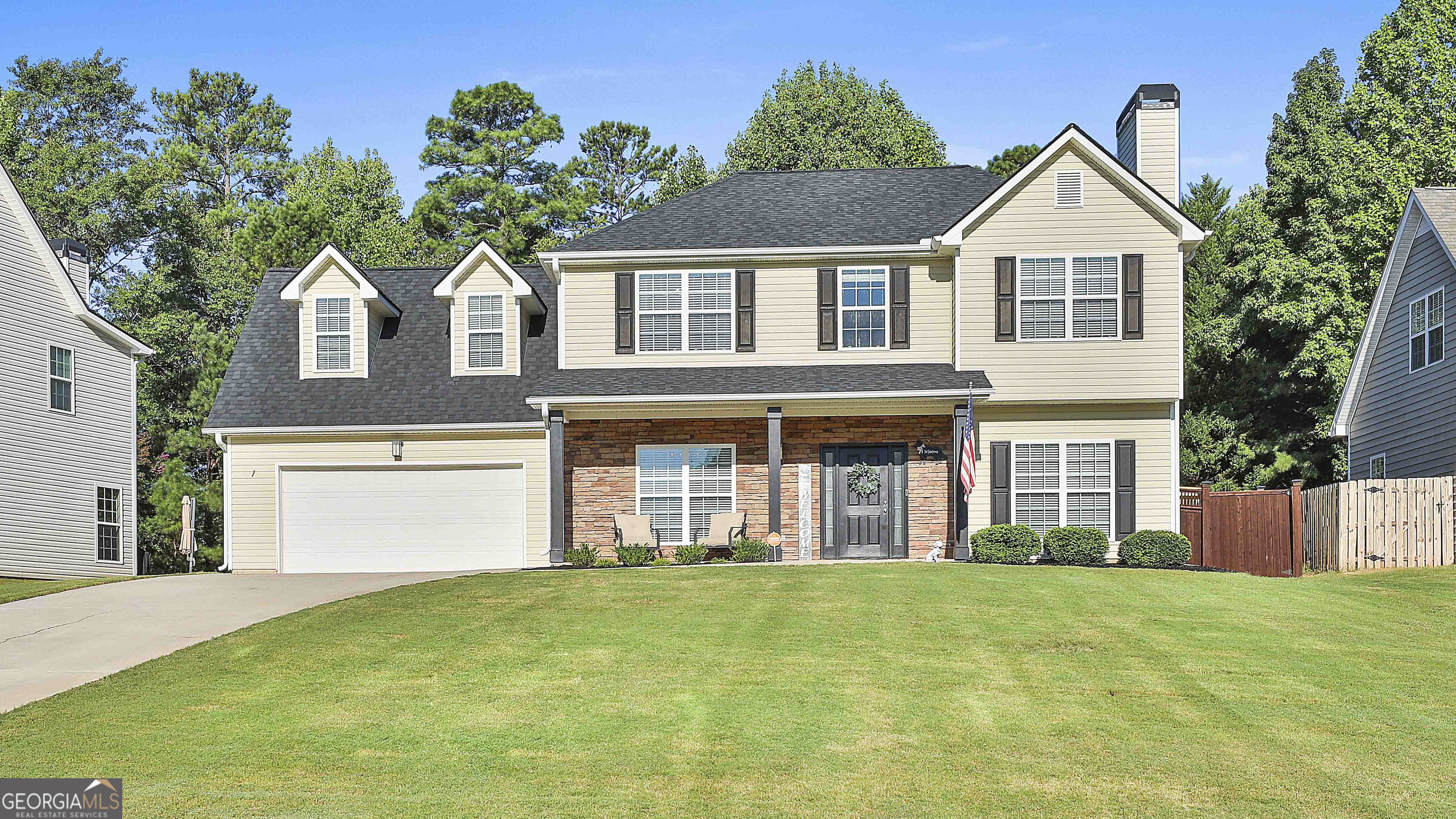 a front view of a house with a garden and yard