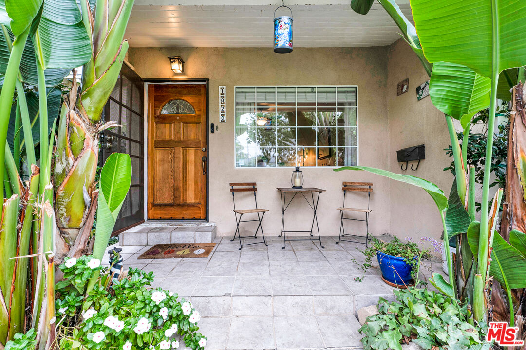 a view of a patio with table and chairs potted plants