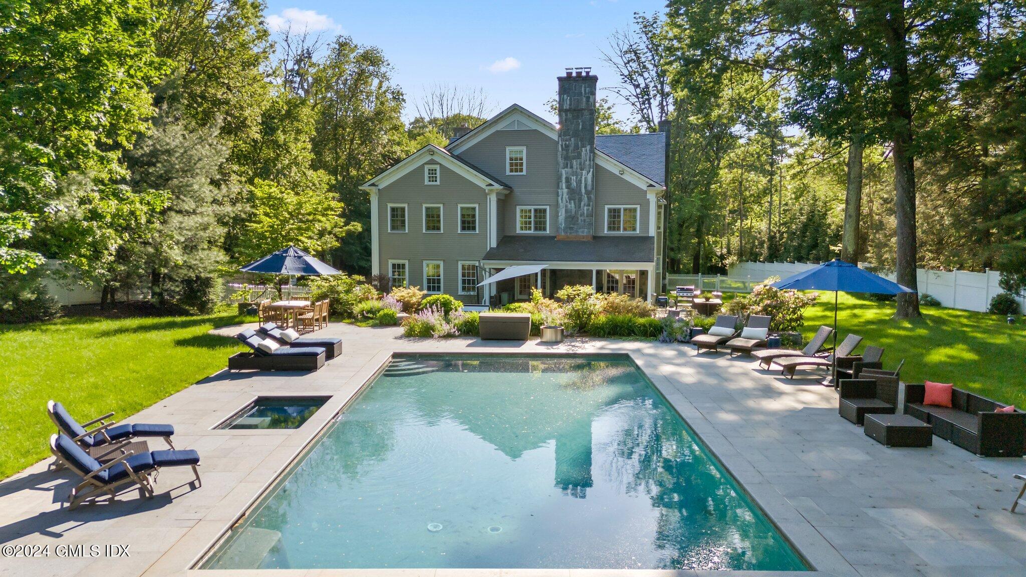 a front view of a house with swimming pool having outdoor seating