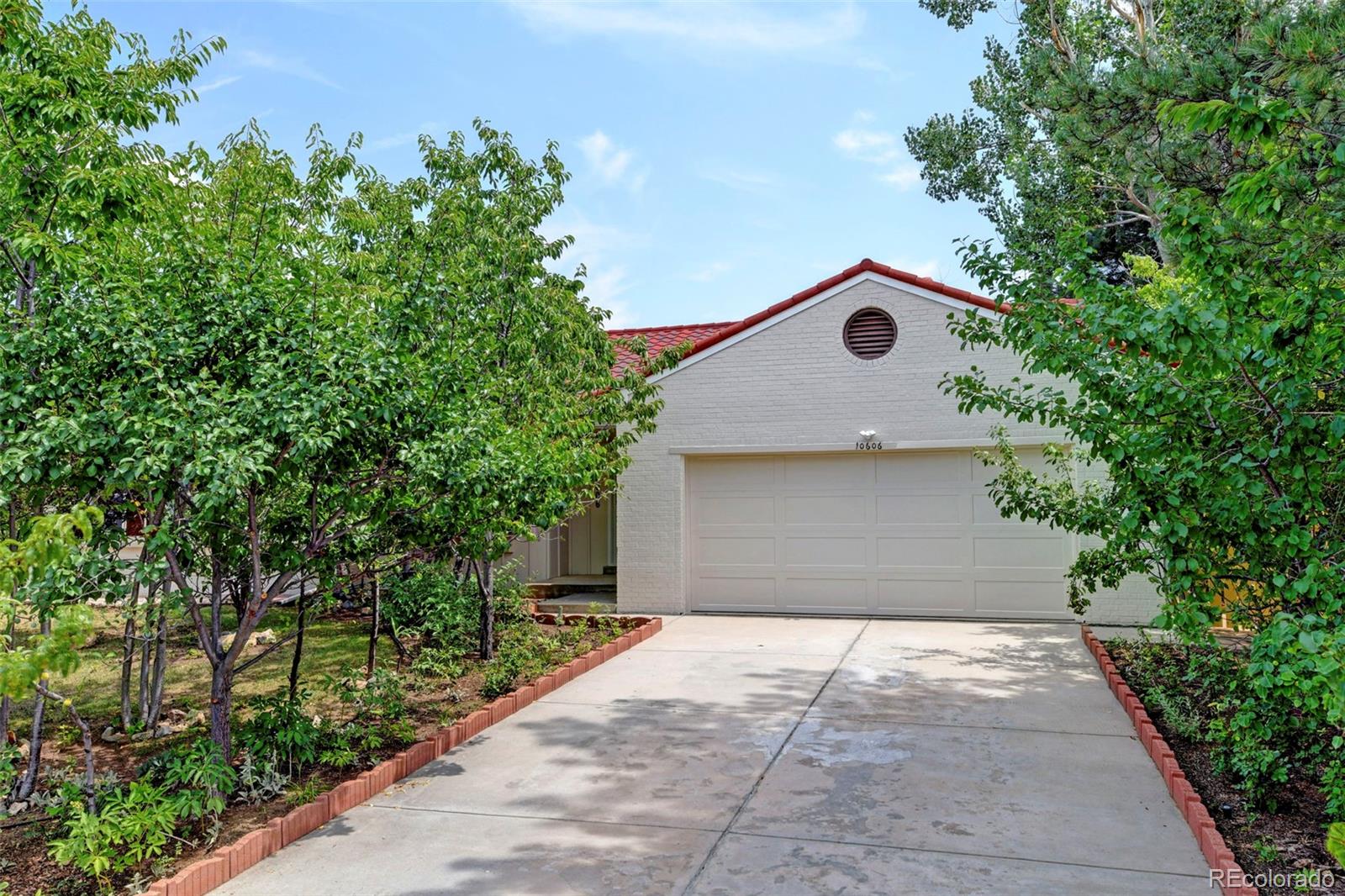 a front view of a house with a yard and trees