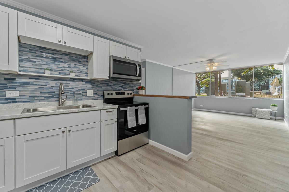 a kitchen with stainless steel appliances granite countertop a stove a sink and a microwave