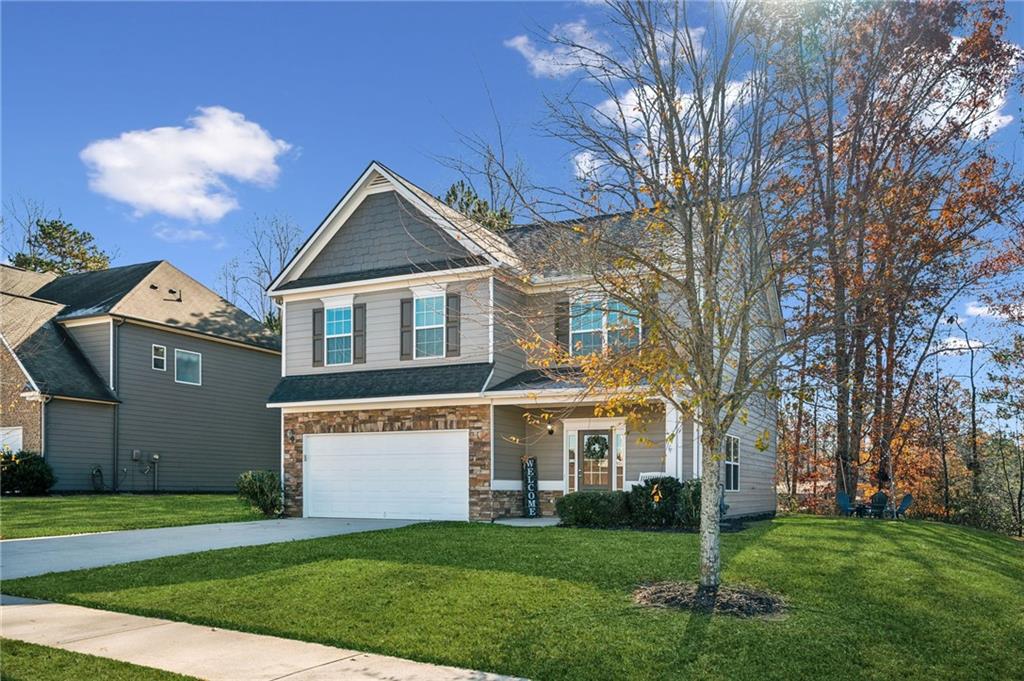 a front view of a house with a yard and trees