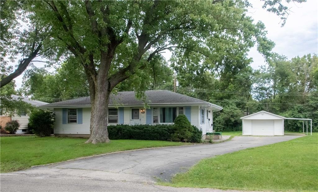 a front view of a house with a yard and trees