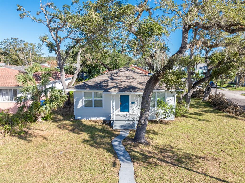 a view of a house with a tree in the yard