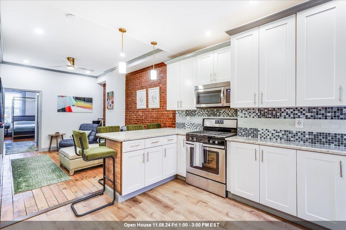 a kitchen with granite countertop a stove a sink and a microwave