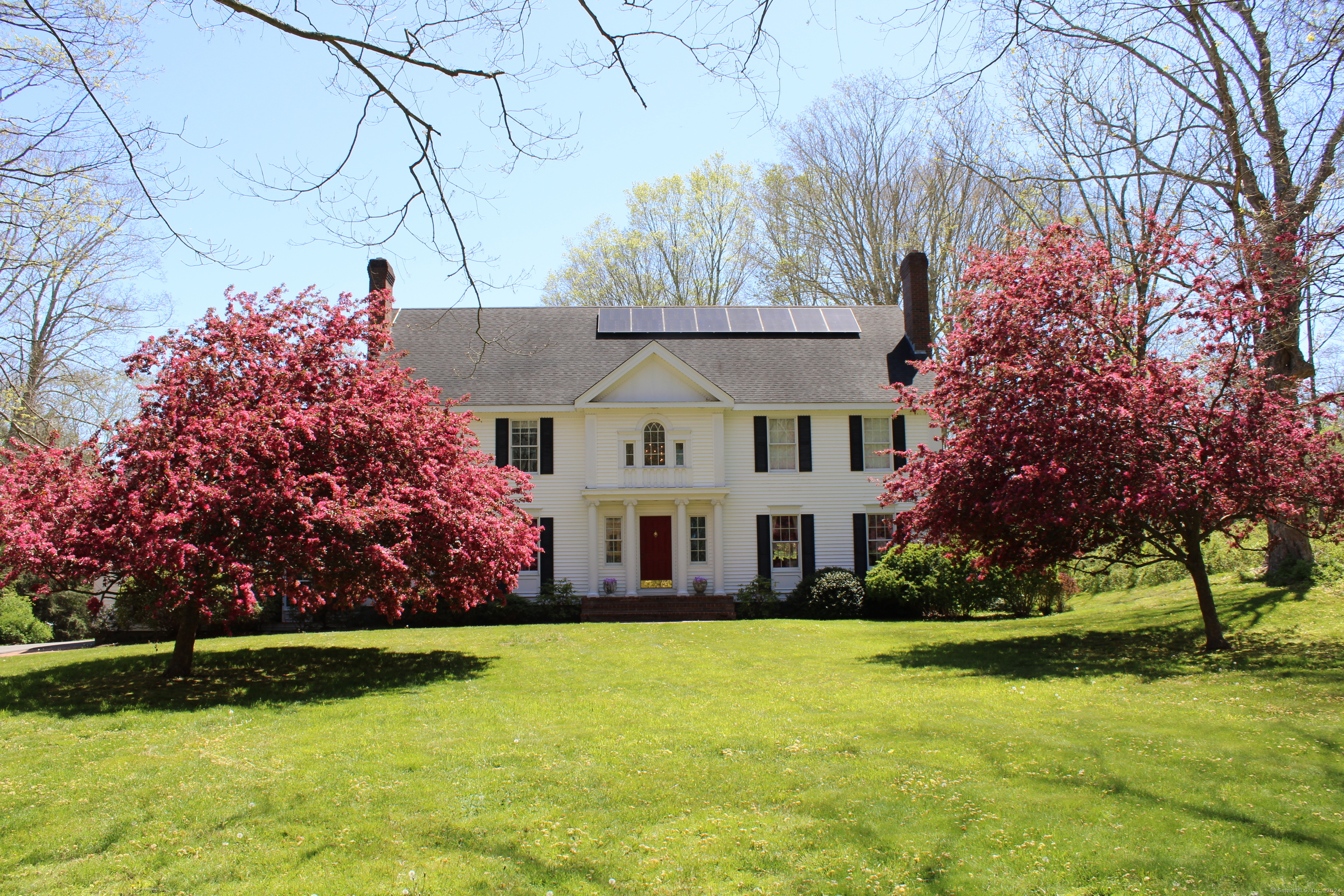 a view of house with yard and outdoor seating