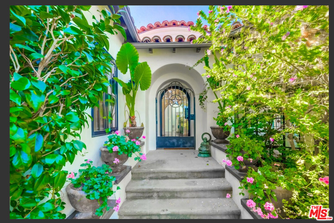 a front view of a house with a garden