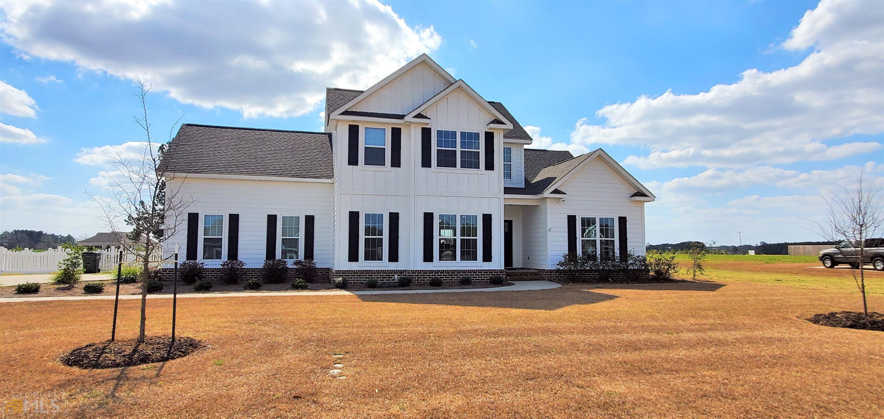 a front view of a house with yard and trees