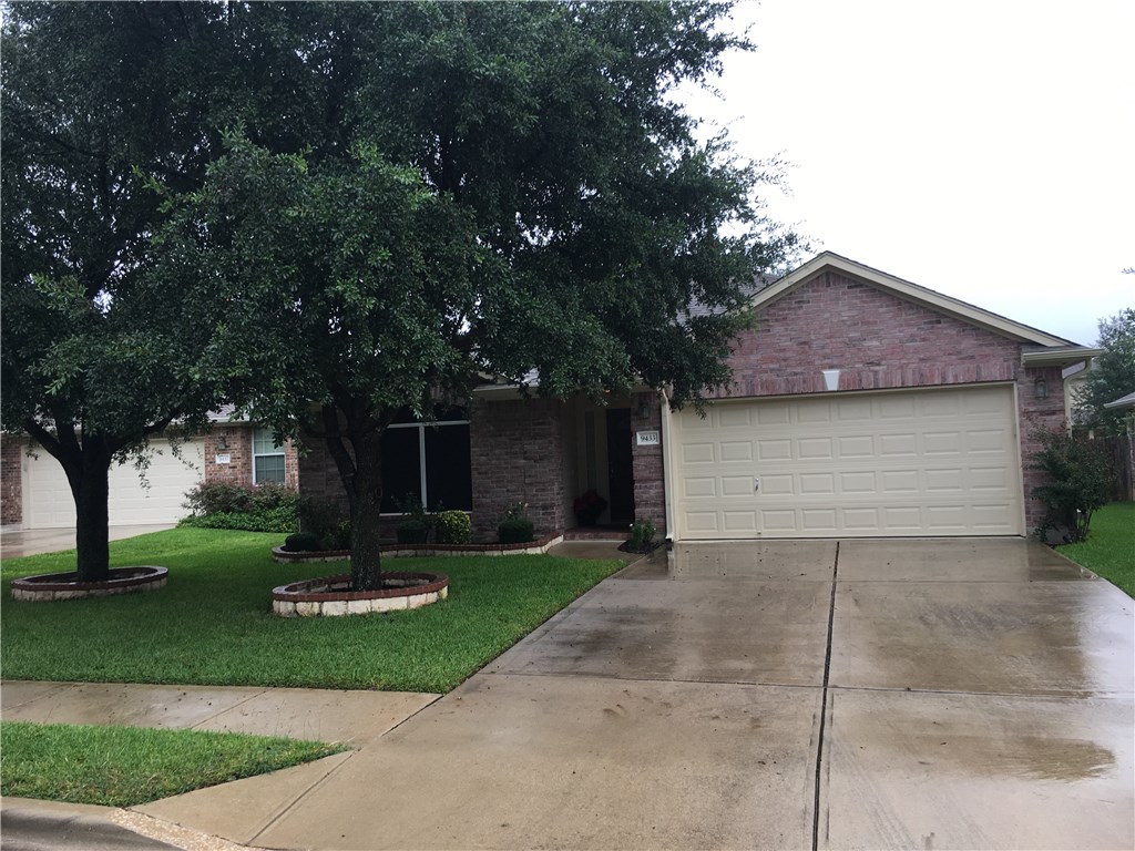 a front view of a house with a yard and tree