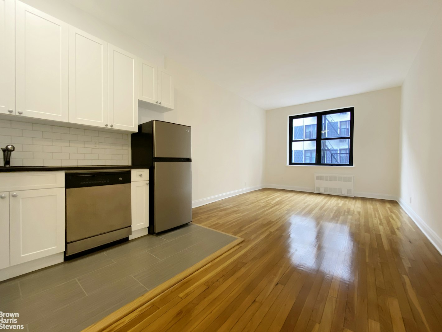 a view of a kitchen with wooden floor and a sink