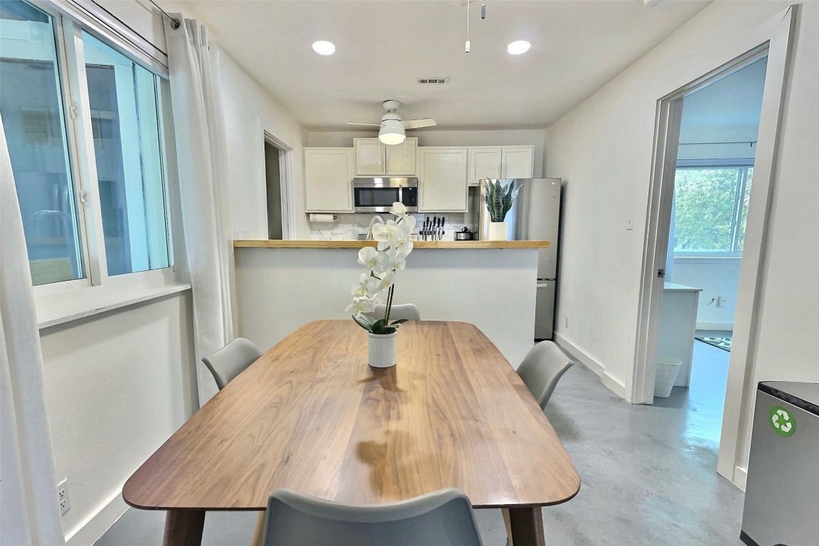 a kitchen with a table chairs refrigerator and microwave