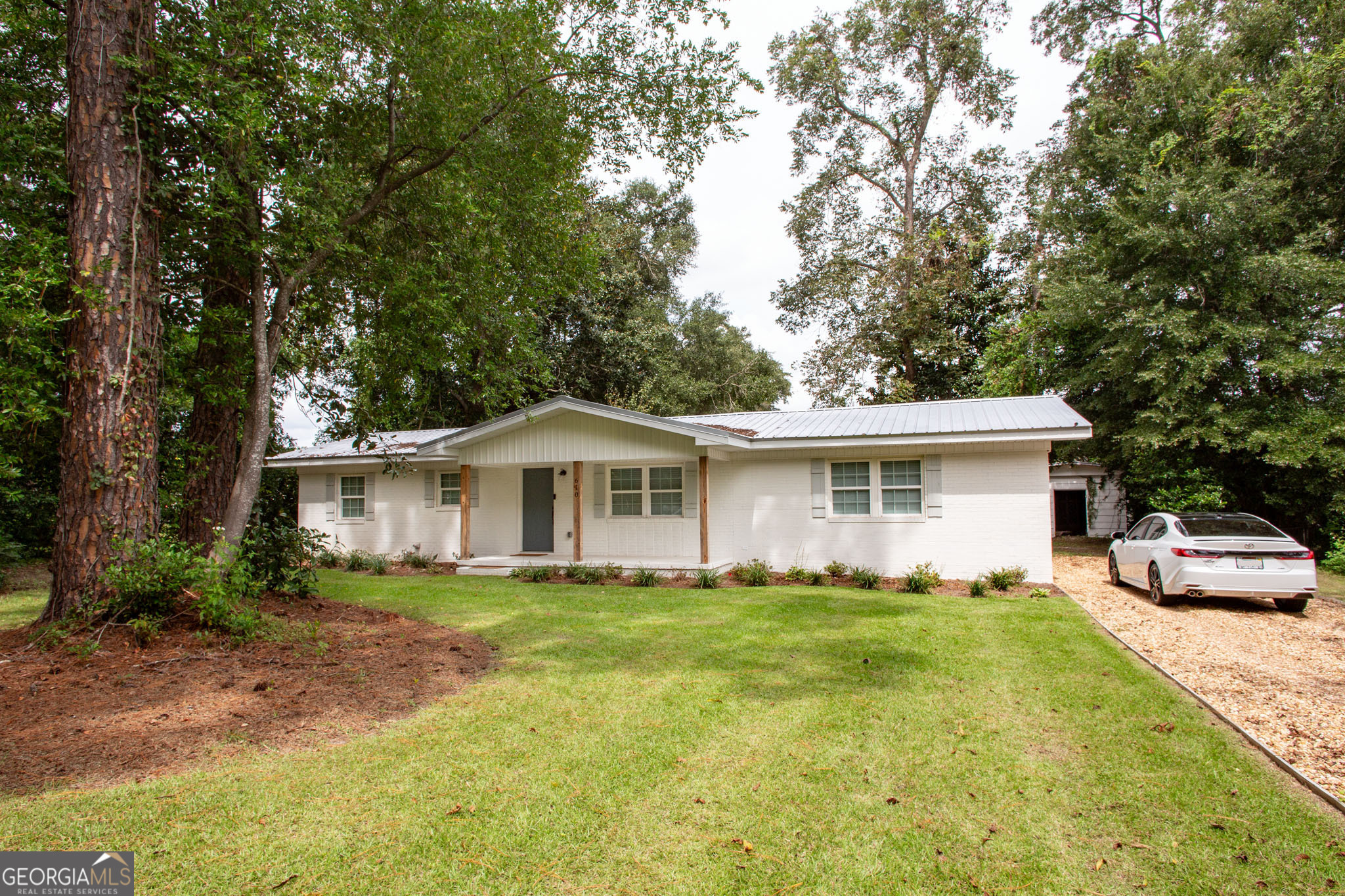 a front view of a house with a garden