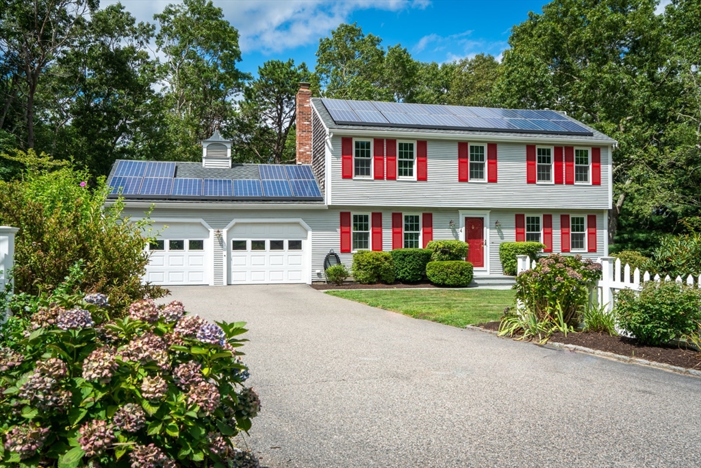 a front view of a house with a yard and trees