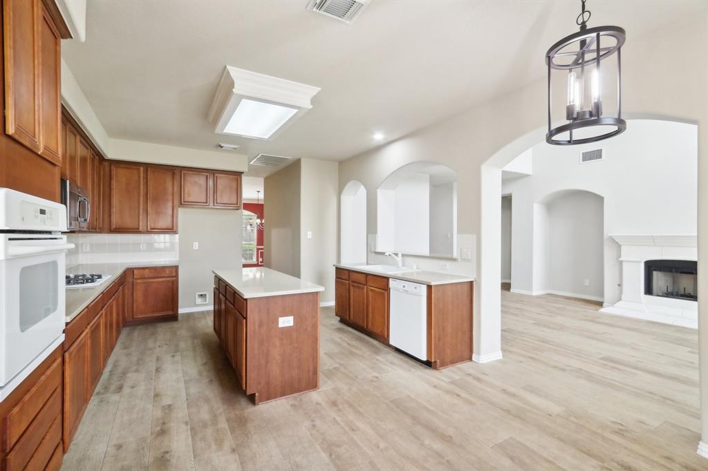 a large kitchen with stainless steel appliances granite countertop a stove oven and a refrigerator