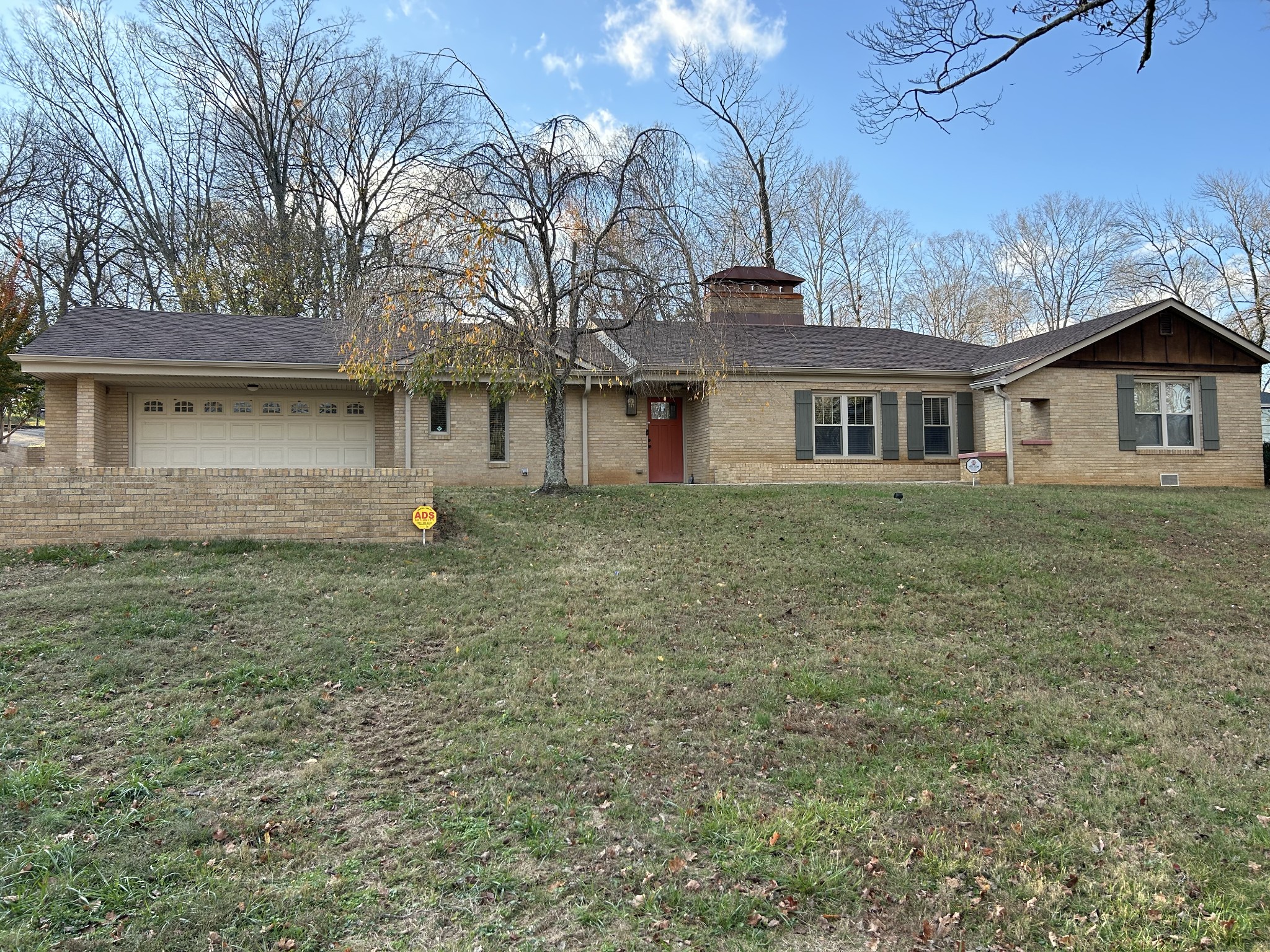 a front view of house with yard and trees around