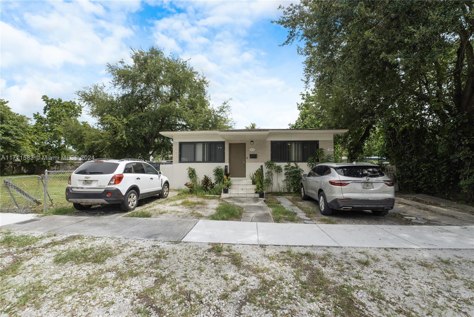 a white car parked in front of a house