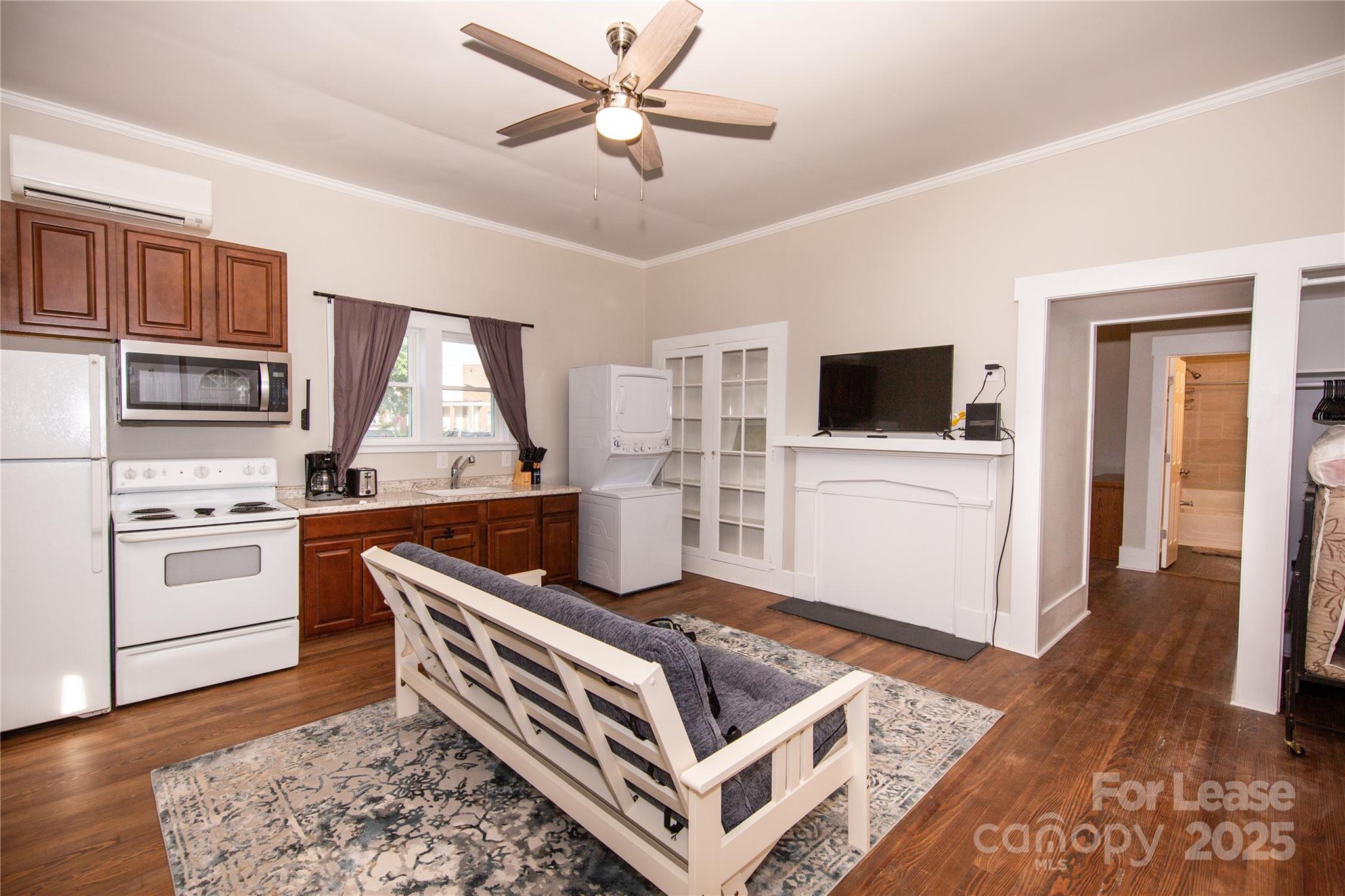 a living room with stainless steel appliances kitchen island granite countertop a stove and a sink