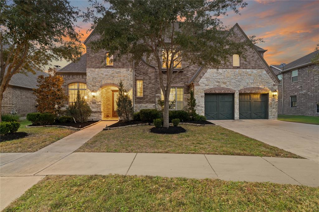 Experience timeless charm with this stunning Highland Homes-built stone and brick elevation, featuring warm lighting and elegant curb appeal.